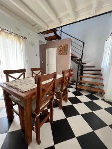 - une salle à manger avec une table et des chaises sur un sol en damier dans l'établissement Departamento para 2 personas, à San Miguel del Monte