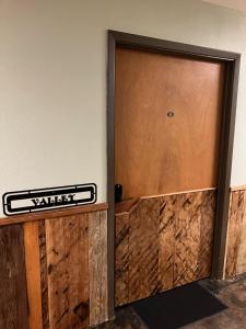 a wooden door with a sign on a wall at Prairie Rose Inn in WaKeeney