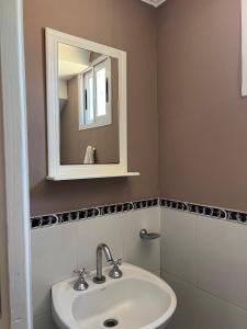 La salle de bains est pourvue d'un lavabo et d'un miroir. dans l'établissement Departamento para 2 personas, à San Miguel del Monte