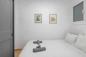 a bedroom with a white bed with two teddy bears on it at Olympic Hadrian view apartment! in Athens