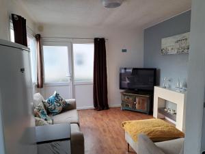 a living room with a couch and a television at Cosy 2-Bed Chalet in Bridlington - Free WiFi in Bridlington