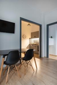 uma sala de jantar com uma mesa e duas cadeiras em Olympic Hadrian view apartment! em Atenas