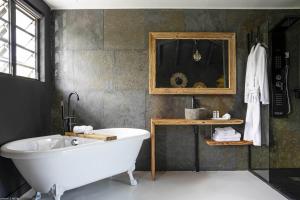 Habitación con baño con bañera blanca. en Pomme Cannelle - Luxury Suites & Spa, en Saint Martin