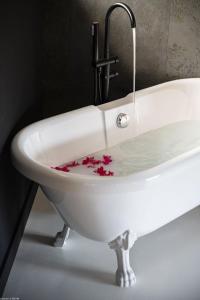 un fregadero blanco con flores en el agua en Pomme Cannelle - Luxury Suites & Spa, en Saint Martin