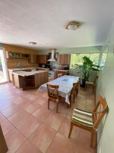 cocina y comedor con mesa y sillas en Villa entre lac et océan, en Biscarrosse