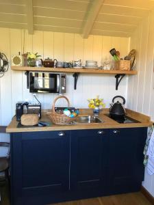 cocina con fregadero y microondas en Pooks Rest, en Hurst Green