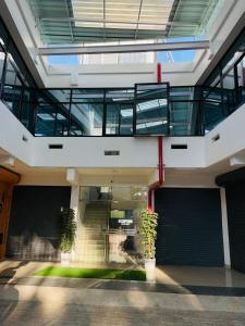 un edificio de oficinas con escaleras y dos macetas en Queen-C Inn, en Mānantoddy