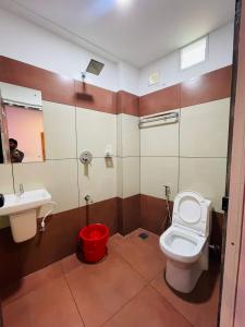 a bathroom with a toilet and a sink at Queen-C Inn in Mānantoddy