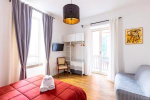 sypialnia z czerwonym łóżkiem, krzesłem i oknami w obiekcie Barrio 133 - double bedroom in center by Napoliapartments w mieście Neapol