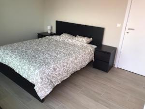 een slaapkamer met een groot bed en een wit dekbed bij Residentie Sluispark in Gent