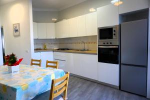 a kitchen with white cabinets and a table with a kitchen gmaxwell gmaxwell gmaxwell at San Clemente with Pool & Wi-fi in Caleta de Interián