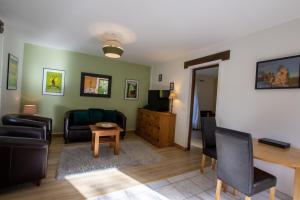 ein Wohnzimmer mit Sofa und Tisch in der Unterkunft La Borie du Cambord - Gîtes et Chambres d'hôtes in Sarlat-la-Canéda