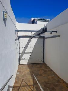 un garaje vacío con paredes blancas y una puerta en San Clemente with Pool & Wi-fi, en Caleta de Interián