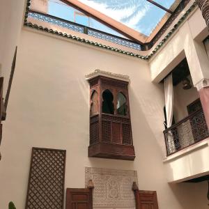 une horloge sur le côté d'un bâtiment avec une fenêtre dans l'établissement Riad Zamzam, à Marrakech