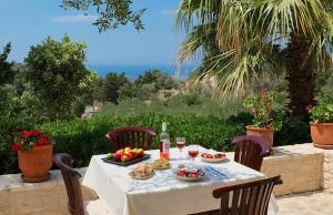 una mesa con una bandeja de fruta y copas de vino en Villa Velanidia, en Amnátos 12 fotos más