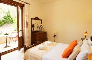 Un dormitorio con una cama y un espejo y una ventana. en Villa Velanidia, en Amnátos