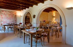 Un comedor con mesas y sillas de madera. en Villa Velanidia, en Amnátos