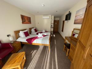 a hotel room with two beds and a tv at Riverside Park & Country Club in South Molton