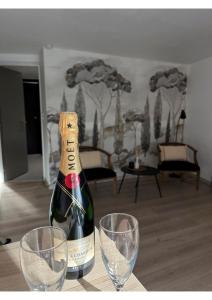 Studio Canadeau في لو كاستليت: زجاجة من الشمبانيا وكأسين من النبيذ على الطاولة
