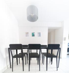 a dining room with black chairs and a chandelier at Cañada 2 dorm in Cordoba