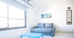 a living room with a blue chair and a table at Cañada 2 dorm in Cordoba