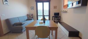 ein Wohnzimmer mit einem Tisch und einem blauen Sofa in der Unterkunft Appartamento Gold Calcara in Calcara