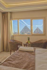 a bedroom with two beds and a large window at The Muse Pyramids Inn Hotel in Cairo