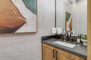 ein Badezimmer mit Waschbecken und Gemälden an der Wand in der Unterkunft Sunset Ridge Mountain Luxury Villa in Mineral Bluff + 92 Fotos