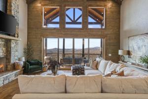 ein Wohnzimmer mit einer weißen Couch und einem großen Fenster in der Unterkunft Sunset Ridge Mountain Luxury Villa in Mineral Bluff