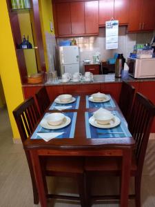 einen Tisch mit Stühlen und Tellern darauf in der Küche in der Unterkunft Annie's House in Syokimau