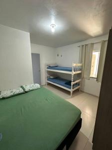 een slaapkamer met een bed en een stapelbed. bij Casa02 - Mariscal/Canto Grande a 150mts da praia in Bombinhas