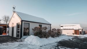 a small white building with snow around it at Pokój Dziupla in Tarnawa Dolna