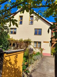 une maison avec une clôture jaune devant elle dans l'établissement Bauernhof Wagner, à Eisenach