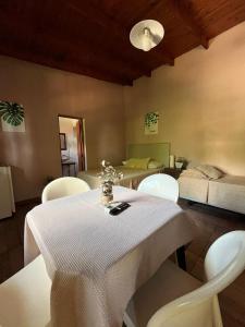 a room with a table and chairs and a bed at LA SELVA MONOAMBIENTES in Puerto Iguazú