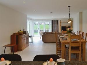 a living room and dining room with a table and a couch at Rose Cottage in Crocketford