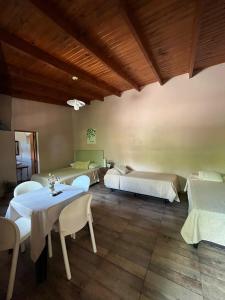 a room with two beds and a table and chairs at LA SELVA MONOAMBIENTES in Puerto Iguazú