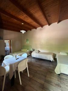 a room with two beds and a table and chairs at LA SELVA MONOAMBIENTES in Puerto Iguazú +21 photos