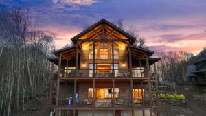 ein Holzhaus im Wald bei Sonnenuntergang in der Unterkunft Sunset Ridge Mountain Luxury Villa in Mineral Bluff