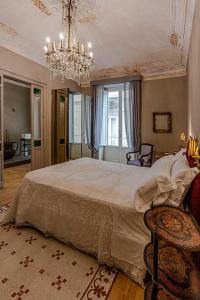 a bedroom with a large bed and a chandelier at La Maison in Syracuse