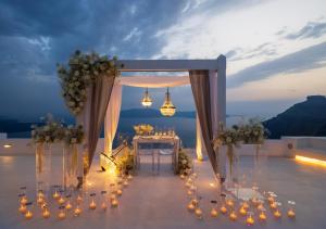 a wedding altar with a table and flowers in a marquee at Dana Villas & Infinity Suites in Firostefani