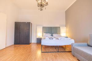 1 dormitorio con cama, sofá y lámpara de araña en Enjoy The Danube and Prater Stern from Our 1BR Gem en Viena