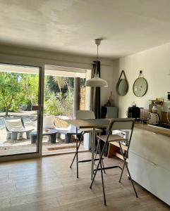 Studio Canadeau في لو كاستليت: مطبخ وغرفة معيشة مع طاولة وكراسي