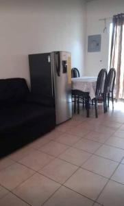 eine Küche mit einem Tisch und Stühlen sowie einem Kühlschrank in der Unterkunft El Hostal 57 in San Juan Opico