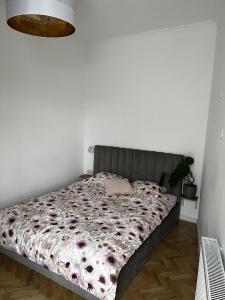 a bed in a bedroom with a white wall at High Standard Room in Jewish District, Apartment Shared with Host in Krakow