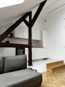 High Standard Room in Jewish District, Apartment Shared with Host في كراكوف: غرفة معيشة مع أريكة ومطبخ