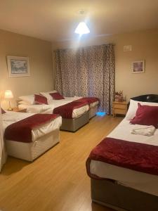 a hotel room with three beds and a window at Luxury Town House-Apartment Carrick-on-shannon in Carrick on Shannon