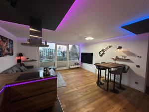 a living room with a table and purple lighting at Stylisches Apartment in Hannover-Langenhagen nähe Messe & Flughafen in Hannover