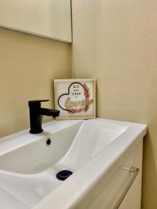 a white sink in a bathroom with a mirror at BaMo Studio - city living arkaden in Klagenfurt