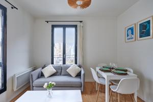 Residence Boulogne Centre le passage by Studio prestige في بولون بيانكور: غرفة معيشة مع أريكة وطاولة