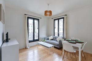 sala de estar con sofá y mesa en Residence Boulogne Centre le passage by Studio prestige en Boulogne-Billancourt